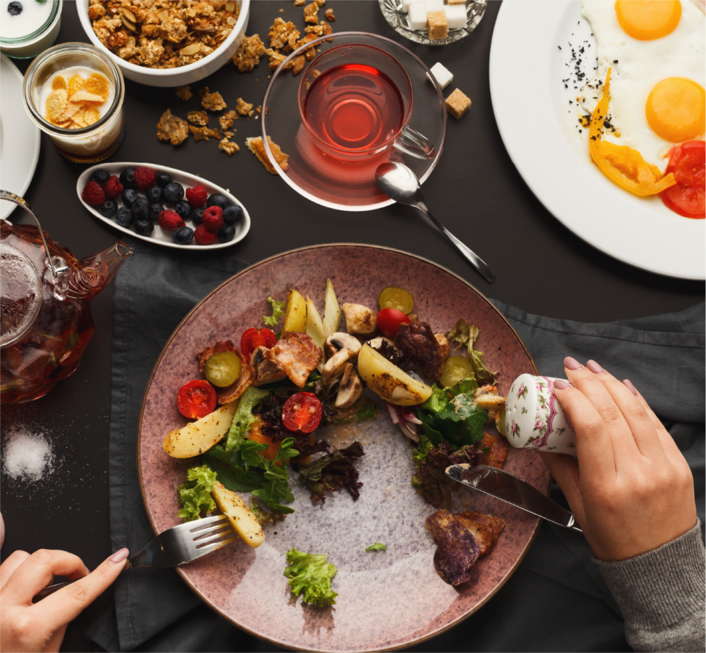 Persona comiendo en una mesa con diferentes platos de comida